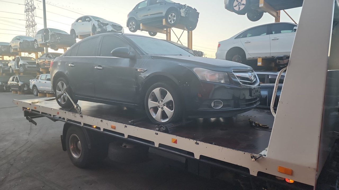 Dark sedan secured on a flatbed transporter