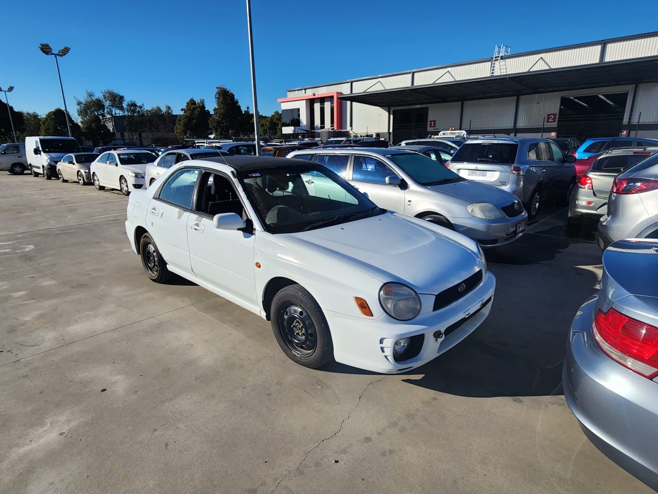 White compact sedan in a vehicle yard