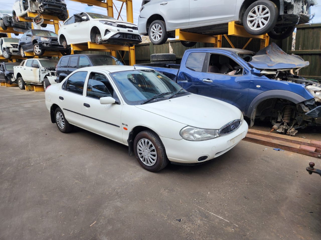 White sedan parked in a vehicle yard