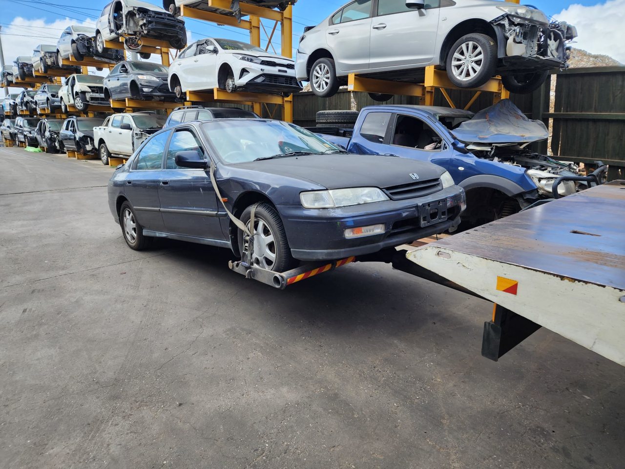 Dark sedan beside a flatbed truck