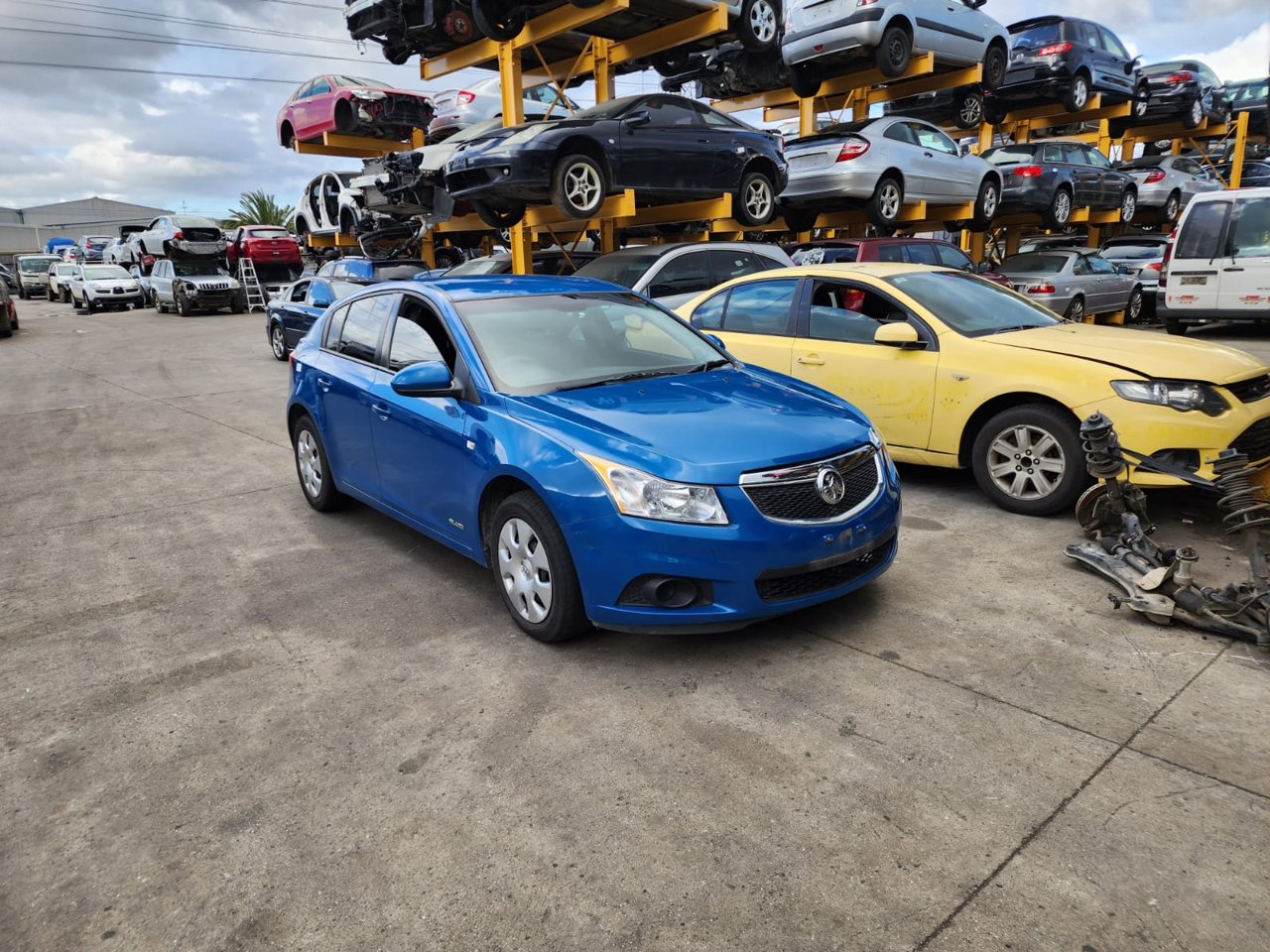 Blue hatchback beside other unwanted cars
