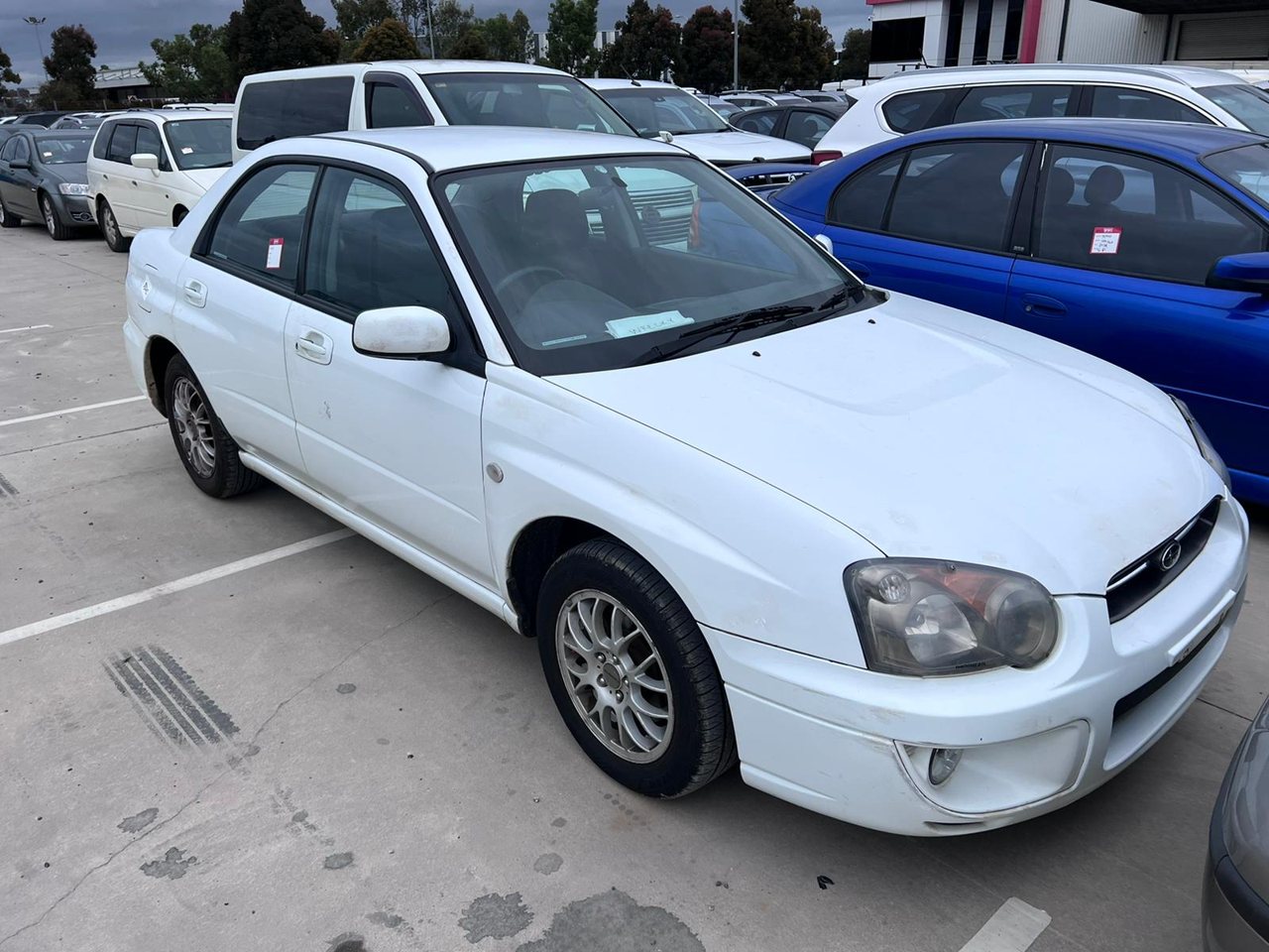 White sedan beside other vehicles