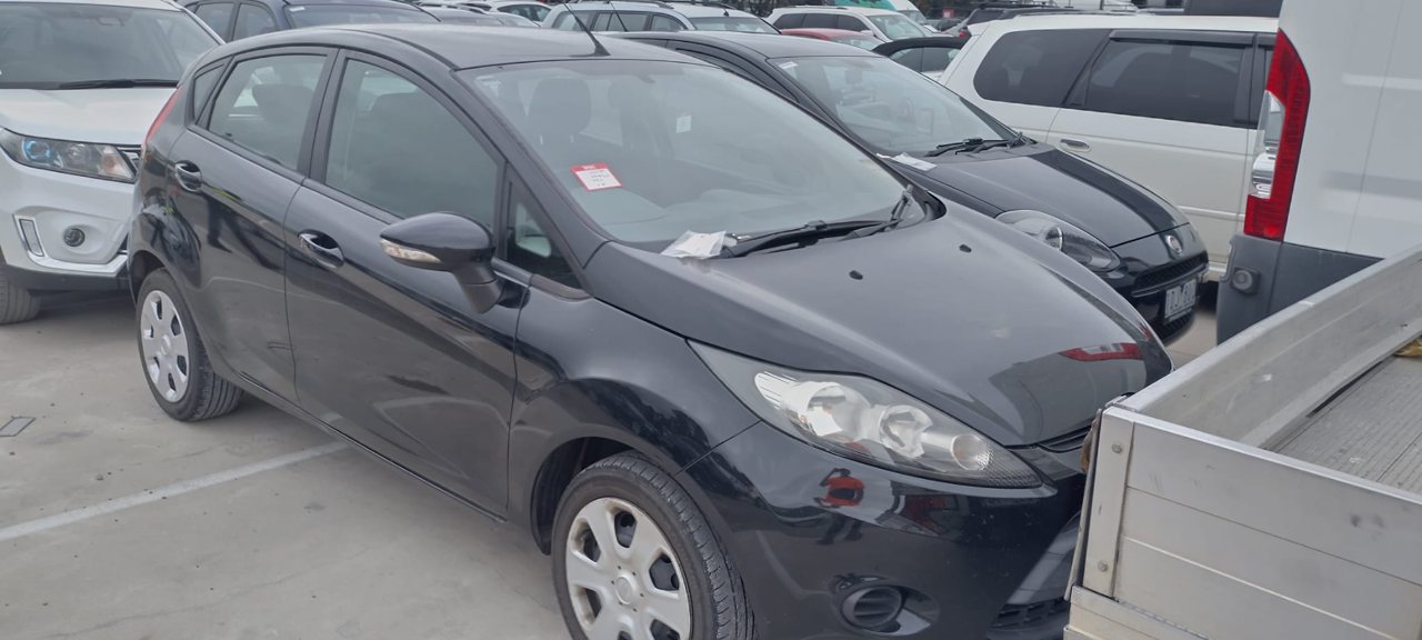 Grey hatchback beside a utility vehicle
