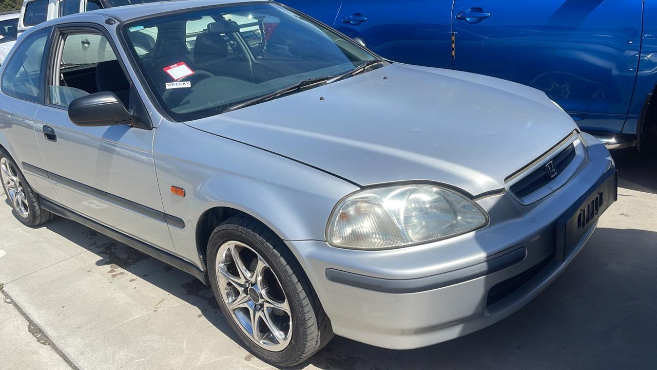 Silver coupe parked in a vehicle yard