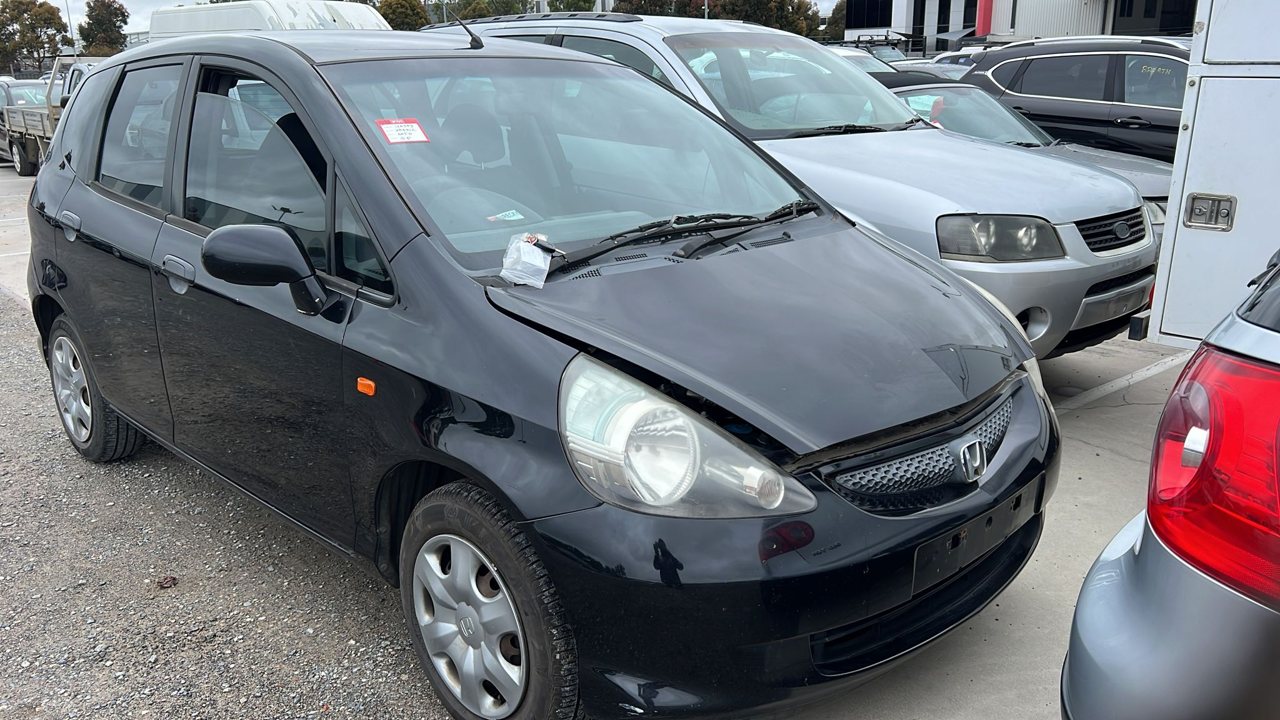 Black hatchback beside other vehicles
