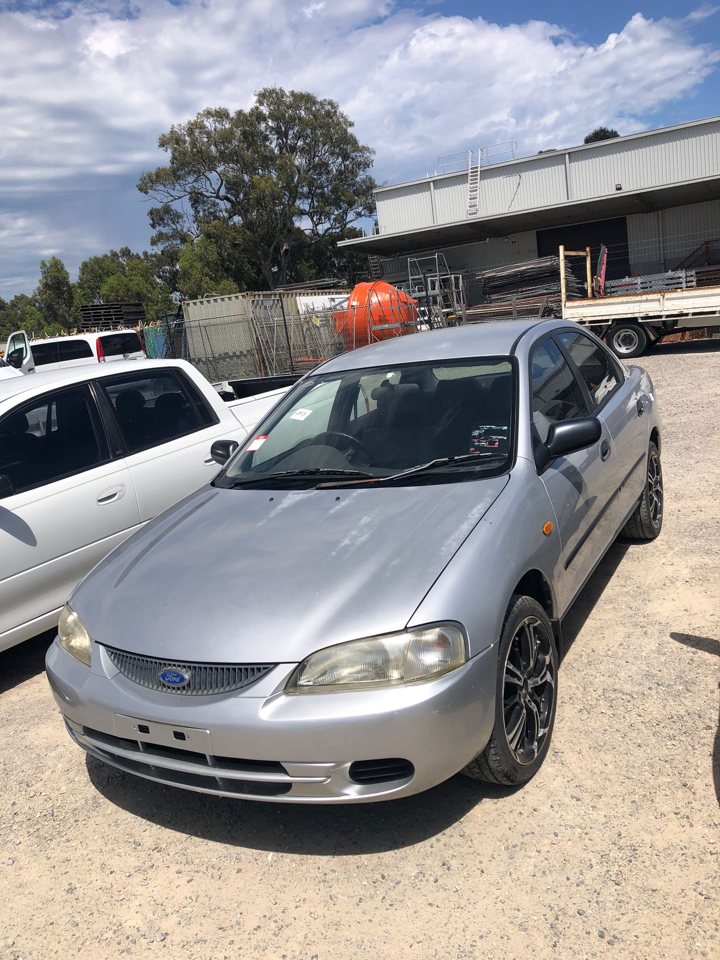Silver sedan in an outdoor vehicle yard