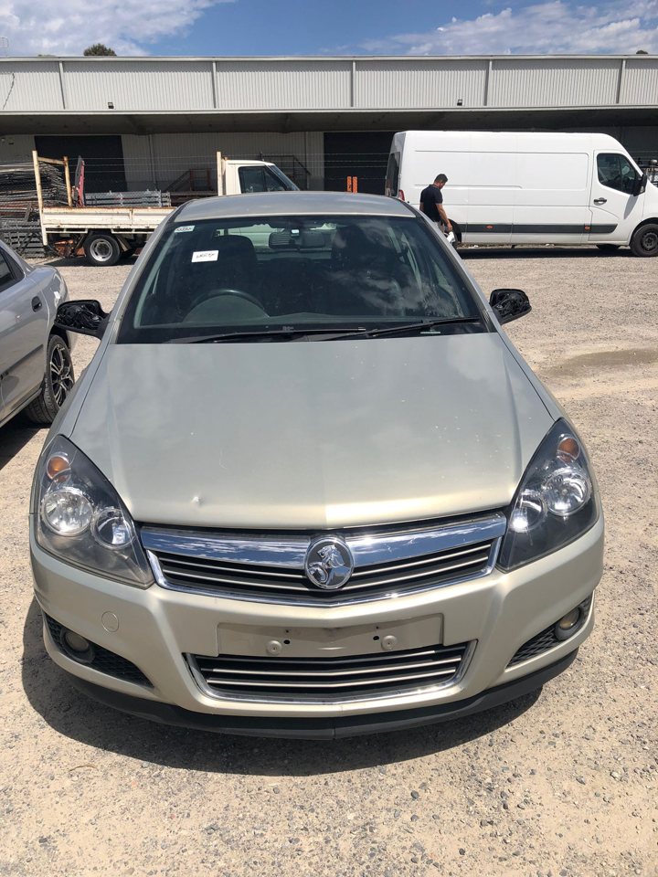 Light-coloured hatchback beside other cars