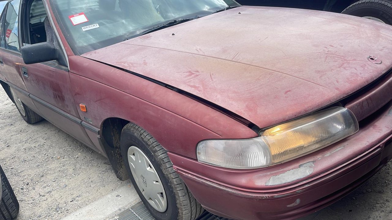 Faded red sedan with visible body wear