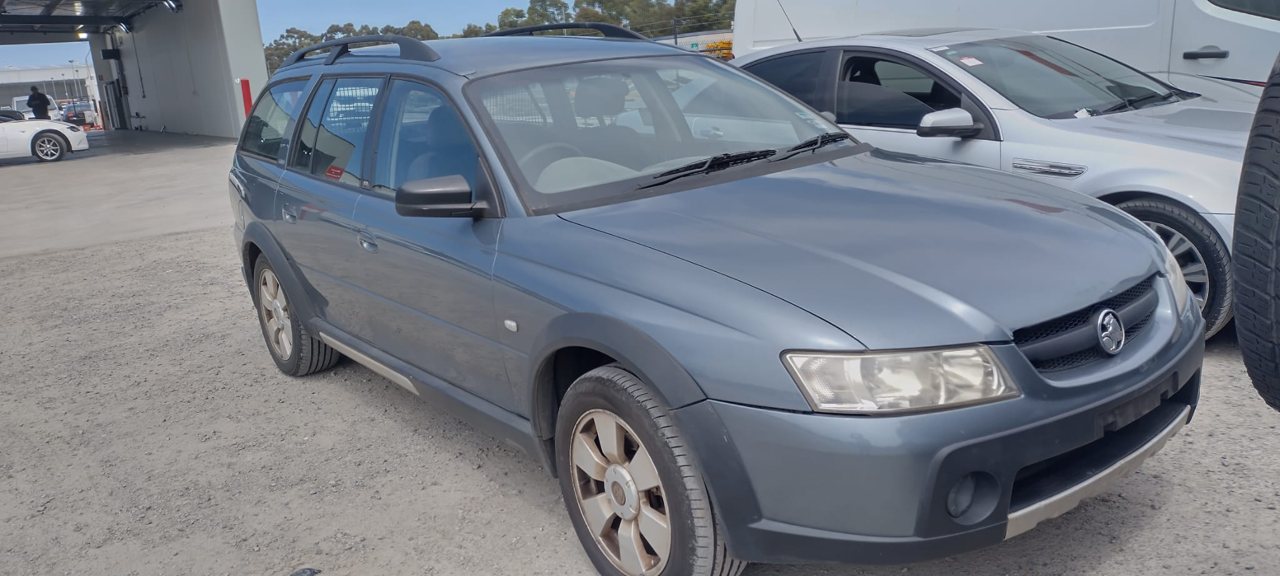 Grey utility vehicle beside other cars